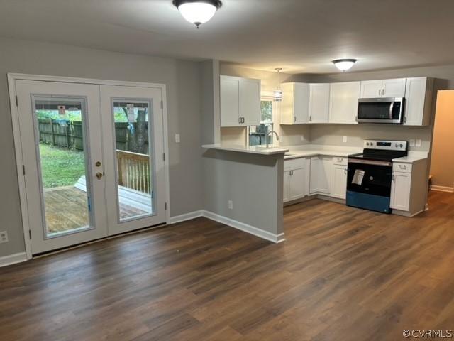 kitchen featuring stainless steel microwave, black range with electric stovetop, light countertops, french doors, and white cabinetry