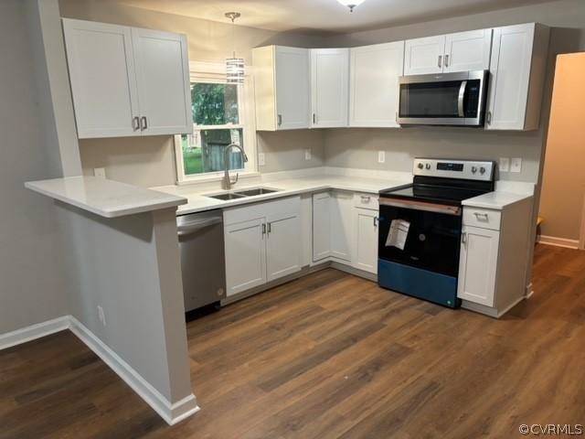 kitchen featuring white cabinets, appliances with stainless steel finishes, light countertops, and a sink