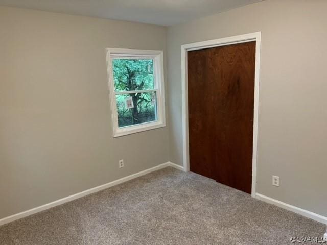 unfurnished bedroom featuring a closet, baseboards, and carpet