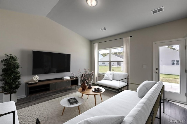 living room with dark hardwood / wood-style flooring, plenty of natural light, and vaulted ceiling