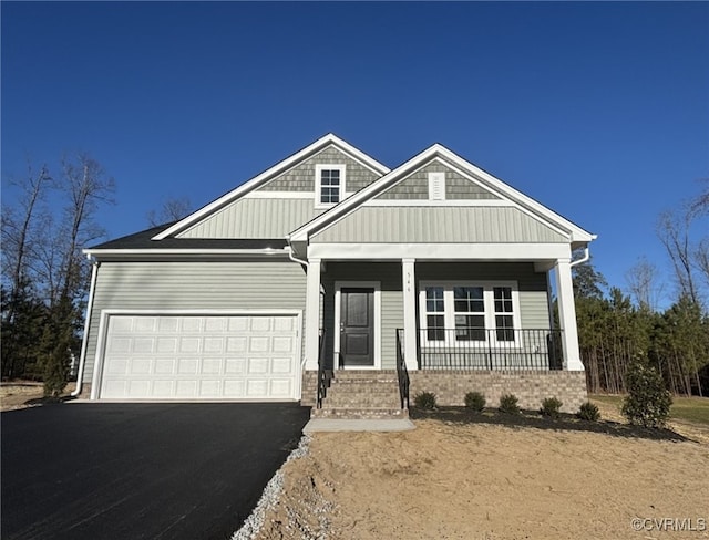 craftsman inspired home with a garage and covered porch