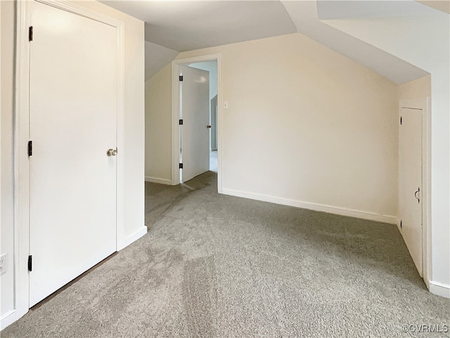 bonus room with light colored carpet and vaulted ceiling