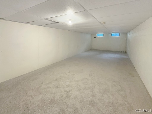 basement with a drop ceiling and carpet