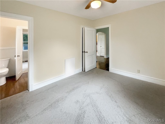 unfurnished bedroom featuring ceiling fan, connected bathroom, and dark hardwood / wood-style flooring