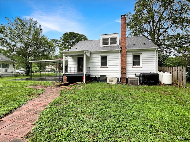 back of house with cooling unit and a yard