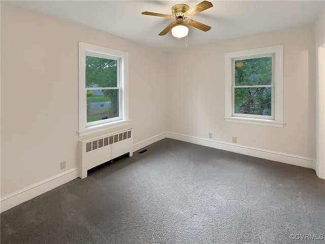 unfurnished room with ceiling fan and radiator