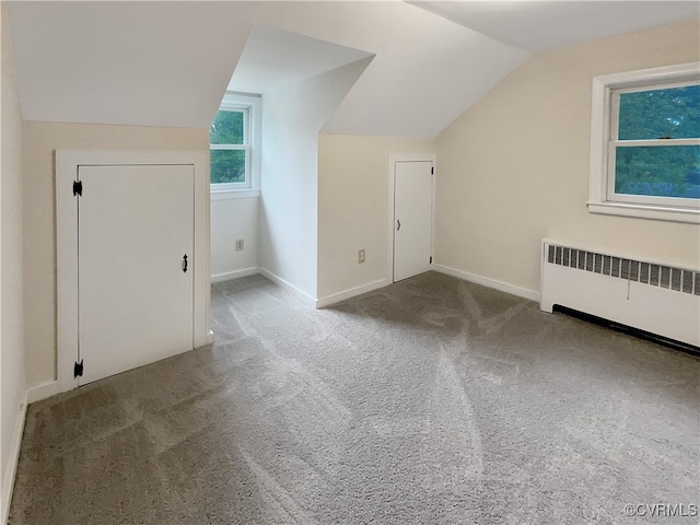 bonus room with carpet flooring, vaulted ceiling, and radiator heating unit