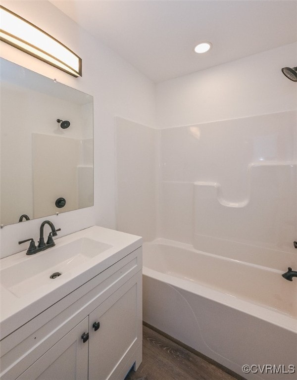 bathroom with hardwood / wood-style flooring, shower / bathtub combination, and vanity