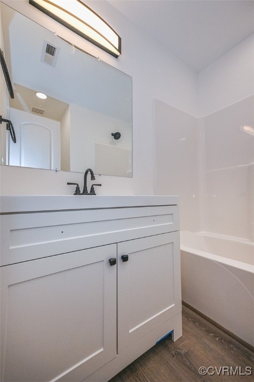 bathroom featuring shower / tub combination, hardwood / wood-style flooring, and vanity