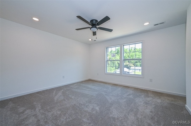 unfurnished room with ceiling fan and carpet