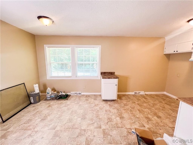 empty room featuring baseboards and visible vents