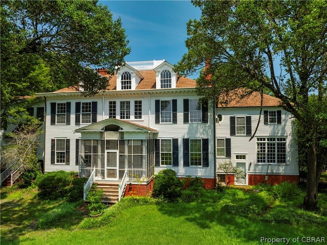 view of front of home featuring a sunroom and a front lawn