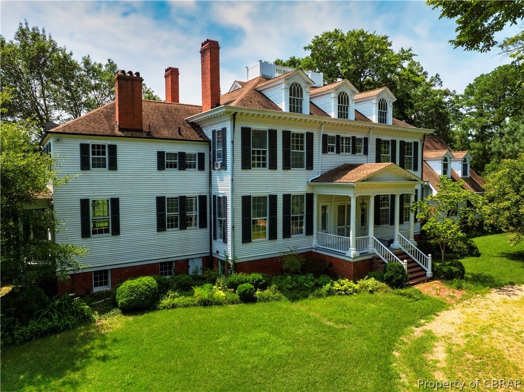 back of house featuring a porch and a lawn