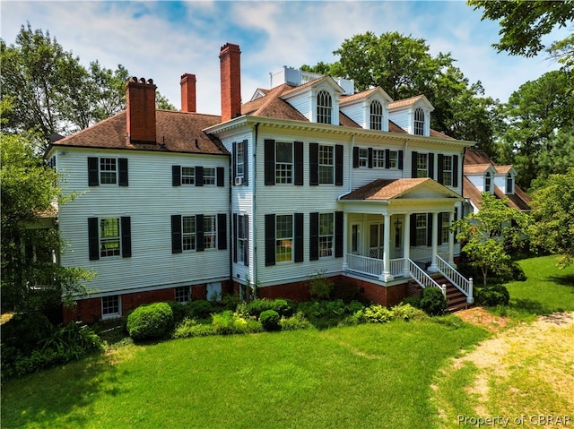 back of house featuring a porch and a lawn