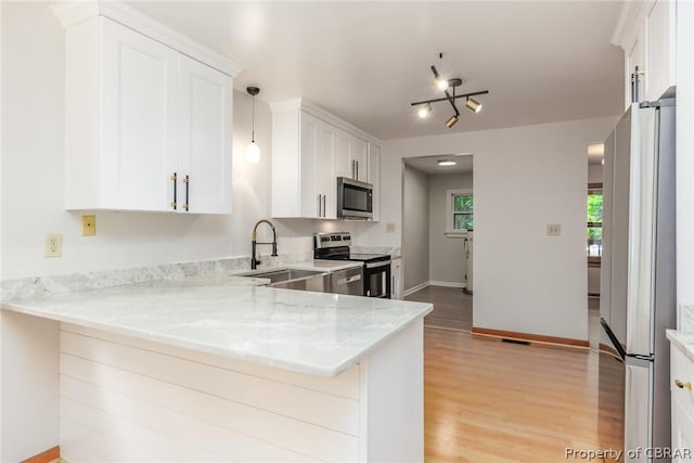 kitchen featuring sink, white cabinetry, kitchen peninsula, stainless steel appliances, and light stone countertops