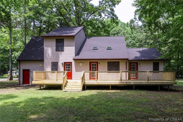 rear view of house featuring a yard and a deck