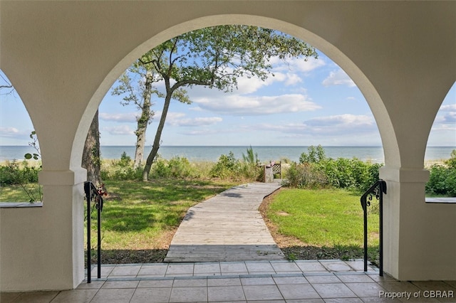 view of community featuring a water view and a yard