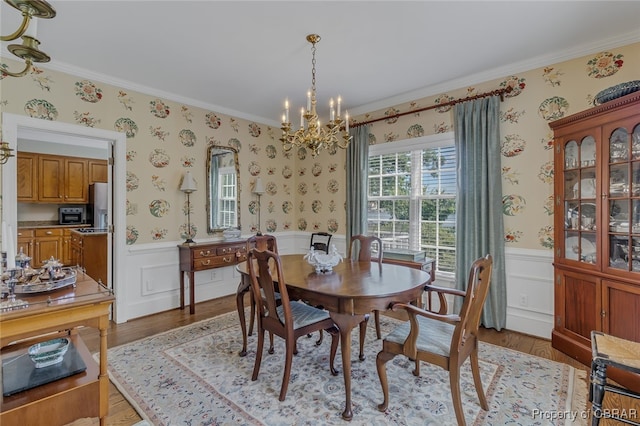 dining space with a chandelier, hardwood / wood-style flooring, and crown molding