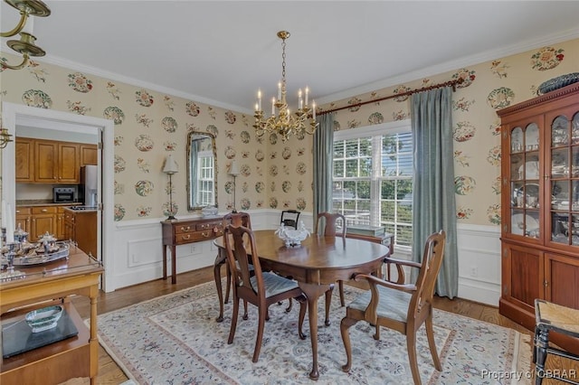 dining room featuring a wainscoted wall and wallpapered walls