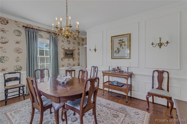 dining area with an inviting chandelier, ornamental molding, and hardwood / wood-style flooring