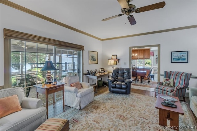 living area featuring light wood-type flooring, a ceiling fan, and ornamental molding
