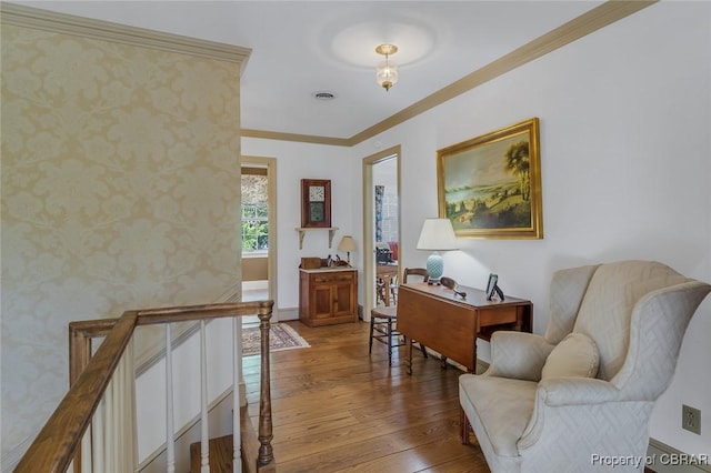 office featuring visible vents, ornamental molding, hardwood / wood-style flooring, wallpapered walls, and baseboards