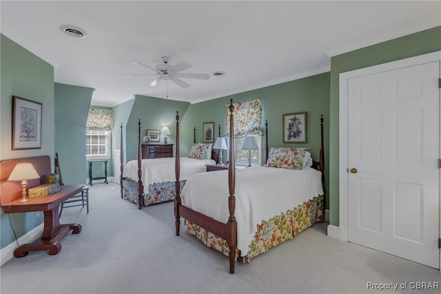 carpeted bedroom featuring visible vents, baseboards, ornamental molding, and a ceiling fan