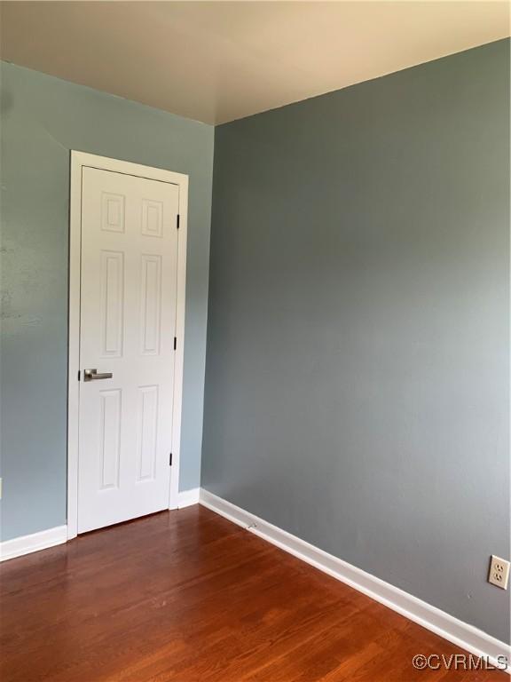 empty room with dark hardwood / wood-style flooring