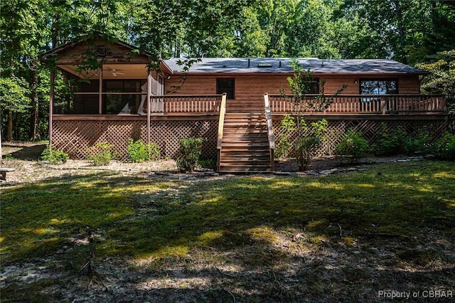 rear view of property featuring stairway, a lawn, a deck, and a sunroom