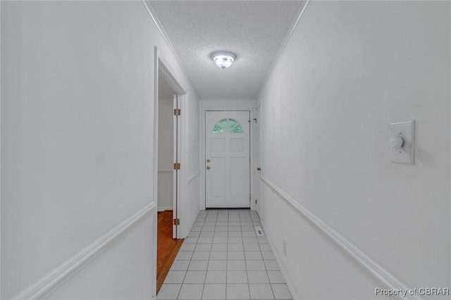 entryway featuring light tile patterned floors and a textured ceiling