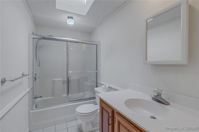 full bathroom featuring vanity, a skylight, tile patterned flooring, a textured ceiling, and toilet