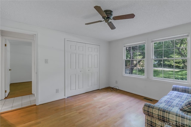 unfurnished room featuring light tile patterned flooring, a textured ceiling, a wealth of natural light, and ceiling fan