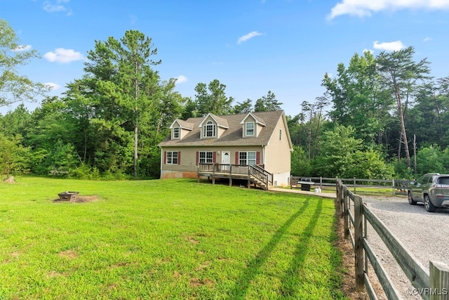 view of front of property featuring a fire pit, a deck, and a front yard