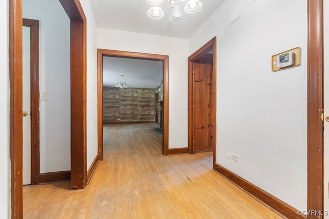 hall featuring a notable chandelier and light hardwood / wood-style flooring