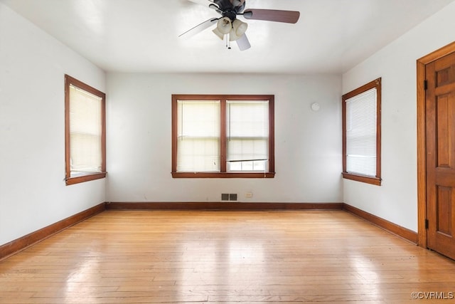 spare room featuring plenty of natural light, ceiling fan, and light hardwood / wood-style flooring