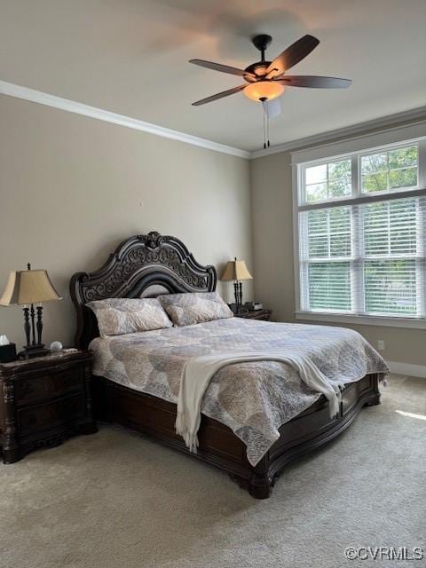 carpeted bedroom with ceiling fan and ornamental molding