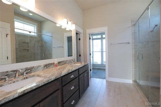 bathroom featuring wood-type flooring, an enclosed shower, and vanity