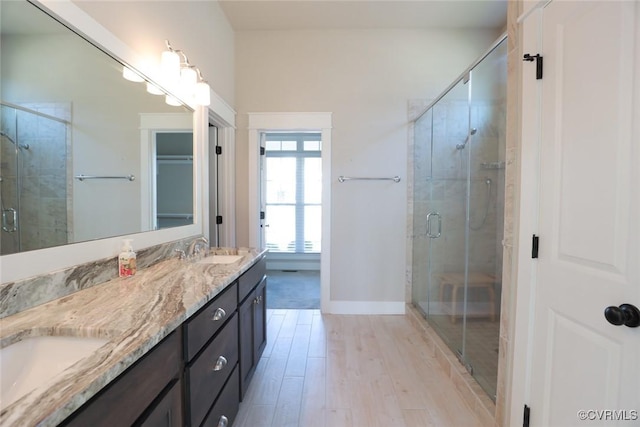 bathroom with vanity, walk in shower, and wood-type flooring