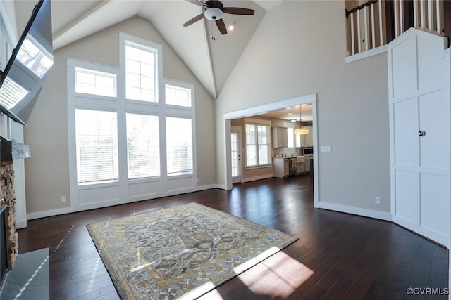 living room featuring a fireplace, dark hardwood / wood-style floors, high vaulted ceiling, and ceiling fan