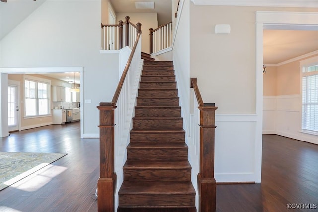 stairway with hardwood / wood-style flooring and crown molding