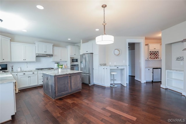 kitchen with backsplash, white cabinetry, hanging light fixtures, and stainless steel appliances