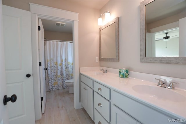 bathroom with hardwood / wood-style flooring, toilet, and vanity