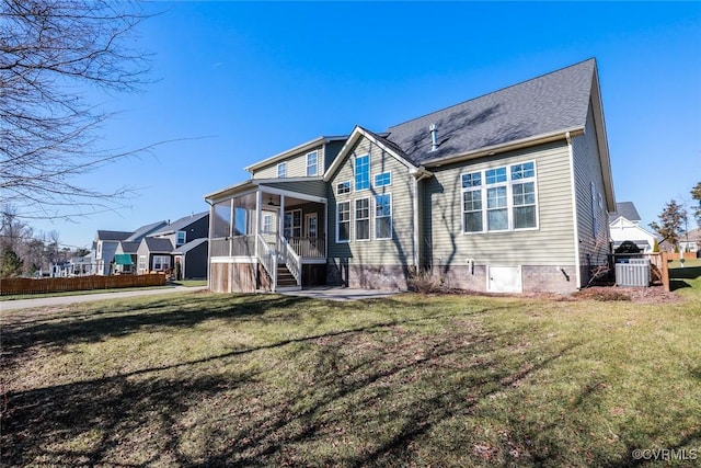 back of house with a sunroom, a lawn, and central AC