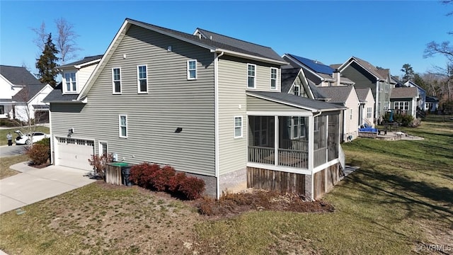 view of side of home with a lawn, a garage, and a sunroom