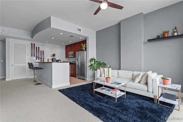 living room featuring light carpet and ceiling fan