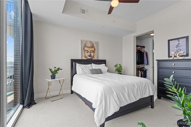 bedroom featuring ceiling fan, carpet flooring, multiple windows, and a spacious closet