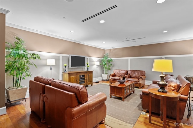 living room with hardwood / wood-style flooring and crown molding