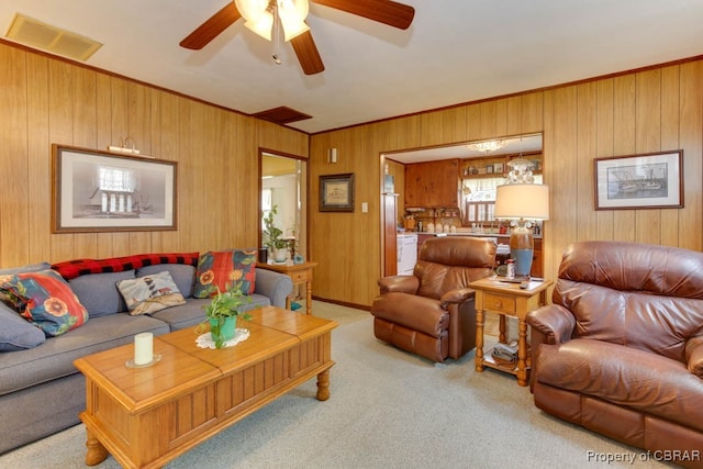 carpeted living room featuring ceiling fan and wooden walls