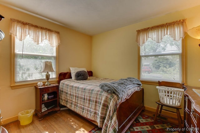 bedroom featuring multiple windows and hardwood / wood-style flooring