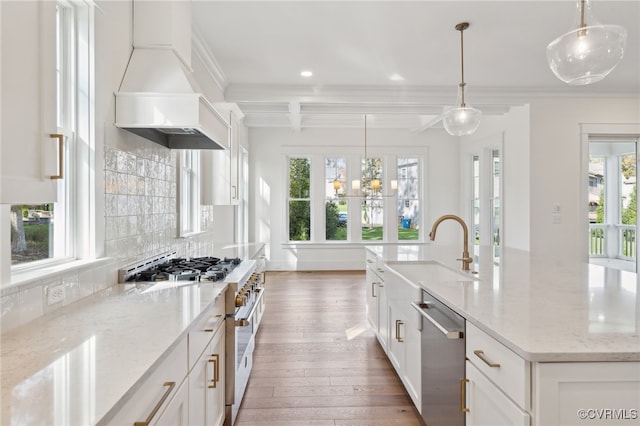 kitchen with a large island with sink, stainless steel appliances, pendant lighting, and white cabinets